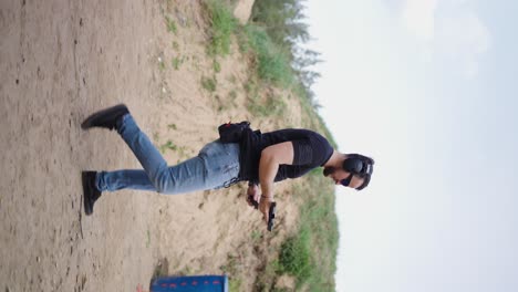 Vertical-view-of-male-shooter-take-position,-insert-magazine-and-fire-bullets