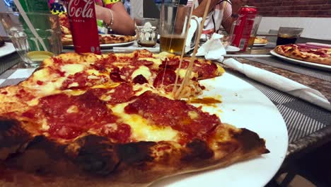 Lifting-a-slice-of-diavola-pizza-in-small-restaurant-in-town