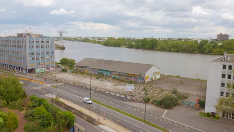 Vista-De-Perfil-De-La-Zona-Industrial-Y-El-Río-Loira-Al-Fondo-Durante-El-Día-En-Nantes,-Francia