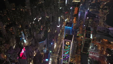 Aerial-top-down-shot-of-traffic-on-highway-in-densely-developed-urbanisation-with-billboards-f-Wan-Cha,-Hong-Kong-at-night