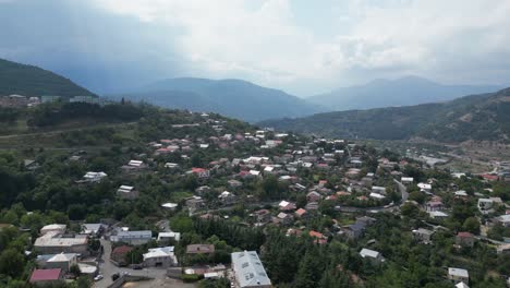 Low-flyover-of-hillside-spa-city-of-Dilijan-in-Armenia,-hazy-overcast