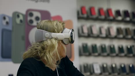 ältere-Frau-Versucht-Apple-Vision-Pro-Headset-Im-Geschäft