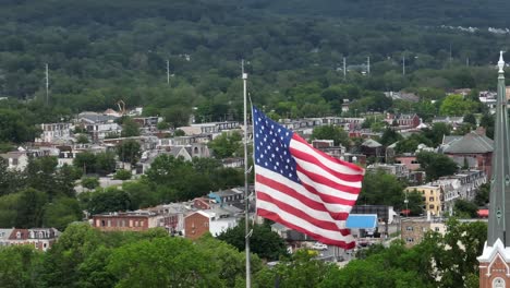 Bandera-Americana-Ondeando-Sobre-El-Barrio-Y-La-Iglesia-En-La-Ciudad-De-EE.UU.