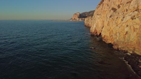Felsige-Küstenklippen-Im-Morgengrauen-Mit-Ruhigem-Blauen-Wasser-Im-Port-Ginesta,-Barcelona