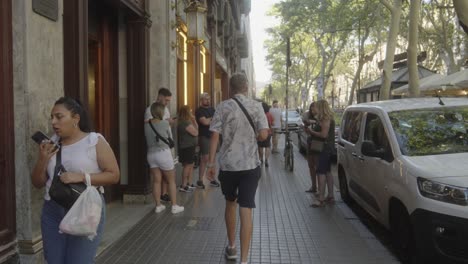 Touristen-Und-Einwohner,-Die-Auf-Den-Belebten-Bürgersteigen-Von-Barcelona,-Spanien,-Spazieren-Und-Das-Pulsierende-Straßenleben-Und-Die-Urbane-Kultur-Einfangen