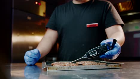 Chef-using-Zokura-meat-thermometer-on-burger-patties-at-restaurant