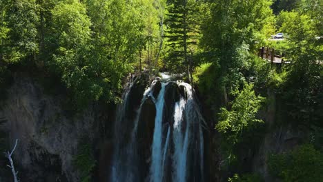 Aerial-parallax-shot-of-the-rushing-water-of-Spearfish-Falls-in-Spearfish-Canyon,-South-Dakota