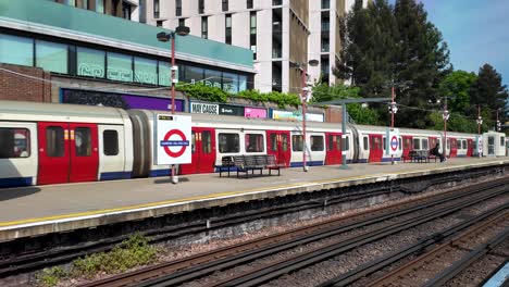 Footage-of-a-Metropolitan-Line-train-departing-from-the-platform-at-Harrow-on-the-Hill-Station,-London,-showcasing-the-concept-of-urban-commuting-and-transportation