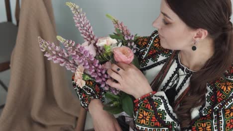 Representa-A-Una-Encantadora-Mujer-Joven-Con-Un-Auténtico-Atuendo-Tradicional-Ucraniano-Sosteniendo-Un-Gran-Y-Hermoso-Ramo-De-Flores-Y-Sonriendo-A-La-Cámara.