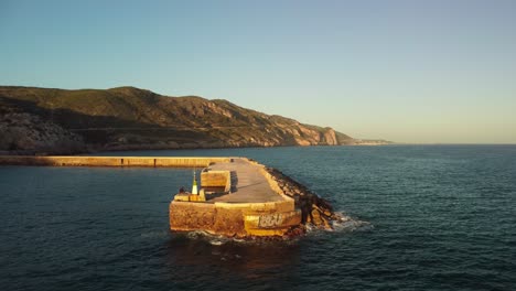 Costa-garraf-pier-with-mountains-and-sea-at-sunset-in-barcelona-spain,-aerial-view