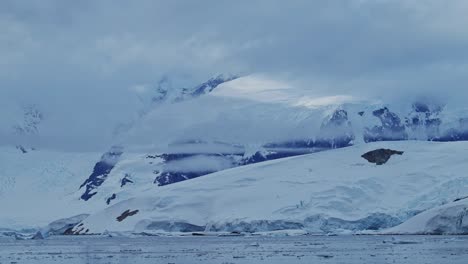 Antarctica-Winter-Mountains-Coastal-Scenery,-Cold-Blue-Landscape-with-Glacier-Ice-Cap-and-Ocean-Sea-Water-on-Coast,-Antarctic-Peninsula-Seascape-in-Dramatic-Moody-Blue-Atmospheric-Scene