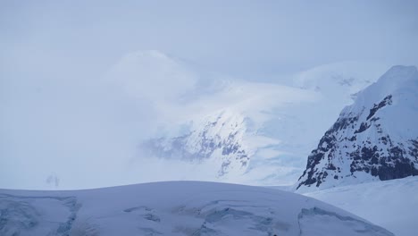 Antarctica-Winter-Mountains-Landscape,-Dramatic-Moody-Blue-Mountain-Scenery-with-Atmospheric-Mood-and-Atmosphere-on-Antarctic-Peninsula,-Snow-and-Ice-Covered-Winter-Icy-Snowy-Mountain-Peaks