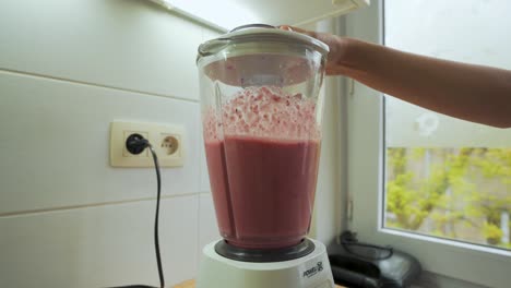 Blending-fruits-in-smoothie-maker-machine,-vegan-vegetarian-healthy-drink