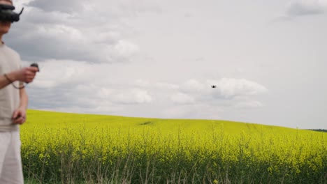 FPV-Drohnenpilot-Beschleunigt-Flugzeug-Mithilfe-Der-RC-Bewegungsfernbedienung-über-Einem-Rapsfeld