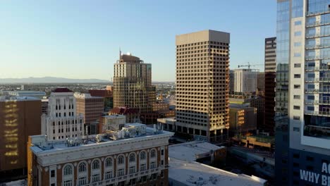 Drone-shot-in-middle-of-buildings-in-downtown-Phoenix,-sunny-day-in-Arizona,-USA