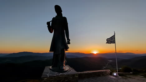 The-Greek-Monument-Honoring-the-Brave-Women-of-Pindos-at-sunset-with-a-Greek-flag