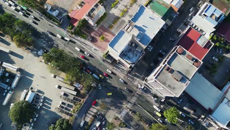 Aerial-top-down-view-of-a-city-intersection-with-heavy-traffic-and-trucks-parked-in-Metro-Manila,-Philippines