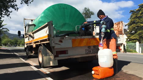 Municipal-worker-with-water-truck-filling-container