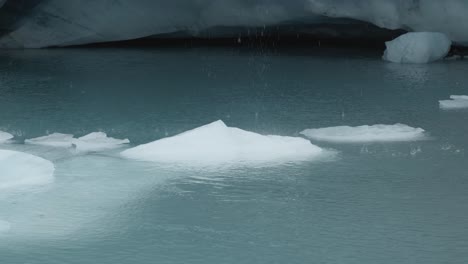 Water-dripping-down-on-ice-in-a-glacier-lake-at-Brewster-Track-in-Mount-Aspiring-National-Park,-New-Zealand