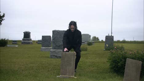 Man-kneeling-at-grave,-mourning-death-of-loved-one