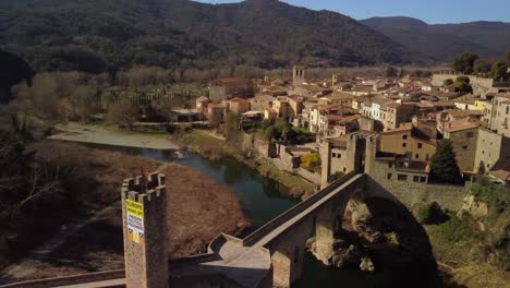 Ciudad-De-Besalú-En-Girona,-España,-Con-Un-Histórico-Puente-De-Piedra-Y-Un-Entorno-Pintoresco,-Vista-Aérea