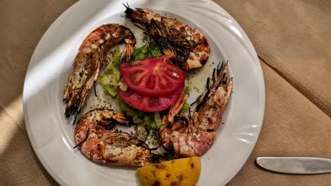 Roasted-large-shrimp-with-tomato-and-lettuce-salad-on-white-plate