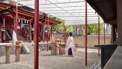 Miko-Young-Priestess-Standing-And-Praying-At-Isagawa-Shrine-In-Nara,-Japan