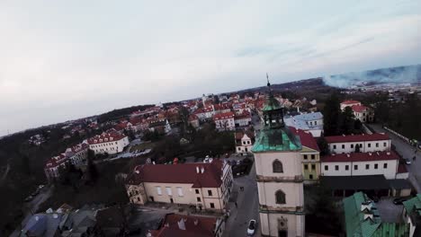 FPV-drone-shot-of-the-old-town-of-Sandomierz,-Poland,-flying-next-to-a-church-tower,-in-the-evening