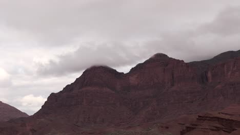 Red-rocky-mountains-in-Cafayate,-Argentina-with-clouds-hanging-low-in-the-sky