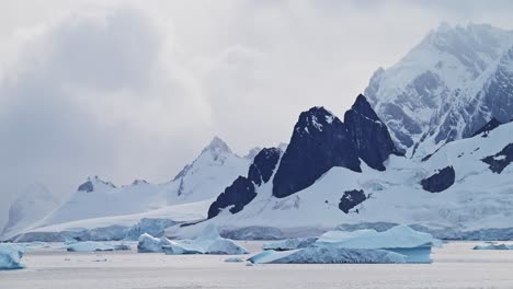 Sonnenuntergang-In-Der-Antarktis,-Schöne-Landschaft-Und-Dramatische-Wolken-Und-Himmel-Mit-Berggipfeln-Und-Eisbergen,-Globale-Erwärmung-Und-Klimawandel-Auf-Der-Antarktischen-Halbinsel-Mit-Meerwasser
