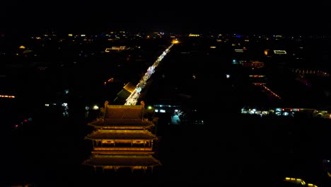 Drone-flying-over-South-Gate-of-Pingyao,-Chinese-old-town-at-night