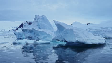 Blue-Ice-Icebergs-in-Antarctica,-Ice-Formation-Floating-on-Ocean-Sea-Water-in-Beautiful-Antarctic-Peninsula-Winter-Scenery,-Amazing-Shapes-in-Nature-in-Coastal-Coast-Scene