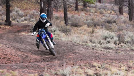 Cinematic-shot-of-dirt-bike-rider-on-a-forest-single-track-trail