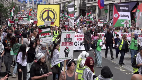Thousands-of-people-march-on-Regent-Street-behind-large-“Campaign-Against-Nuclear-Disarmament”,-“Palestine-Solidarity-Campaign”-and-“Stop-The-War-Coalition”-banners-during-a-Nakba-day-protest-march