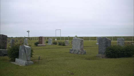Graveyard-tombstones-and-graves-in-cemetery-on-gloomy,-cloudy-day