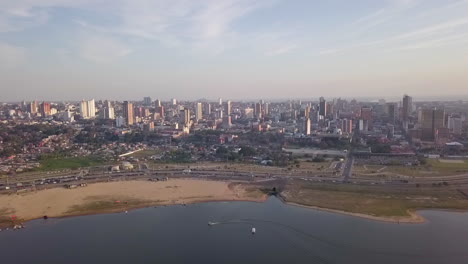 Toma-Panorámica-Aérea-De-La-Bahía-De-Asunción-Con-El-Río-Paraguay-Fluyendo-Por-El-Exterior-Con-Pequeñas-Embarcaciones-Ancladas.