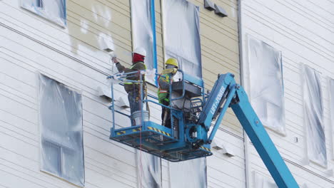 A-worker-uses-a-lift-to-reach-the-sides-of-a-new-construction-build