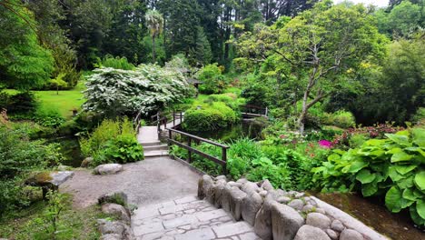 Japanese-Garden-in-Powerscourt-Wicklow-path-leads-to-bridge-over-pond-and-beautiful-landscape-in-summer