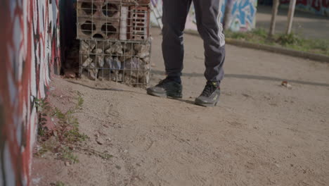 Anonymous-graffiti-artist-feet-movement-in-dirt-floor-painting-vandalism-street-art-in-Barcelona