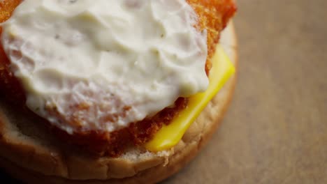 Open-bun-reveal-mayonnaise,-fish-burger,-cheese,-junk-food,-unhealthy