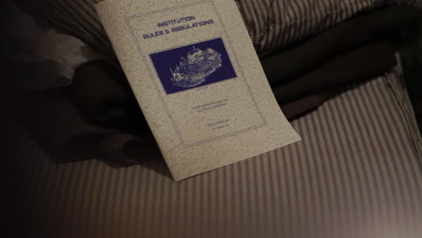 Alcatraz-Prison-Cell-With-Institution-Rules-and-Regulations-Pamphlet-on-Bed,-California-USA