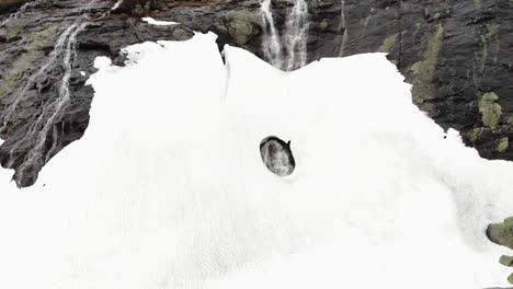 Ein-Loch-In-Einem-Schmelzenden-Schnee-Auf-Einem-Wasserfall
