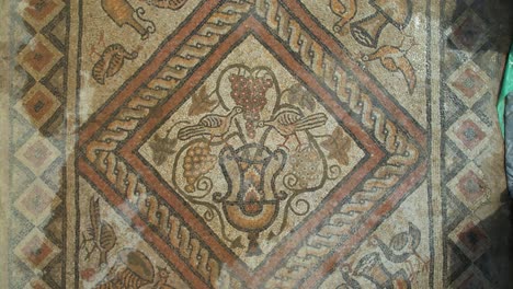 Ancient-Roman-Mosaic-on-the-Floor-of-an-Old-Building-atop-a-Hill,-Surrounded-by-the-Emerald-Waters-of-Lake-Lin,-Pogradec