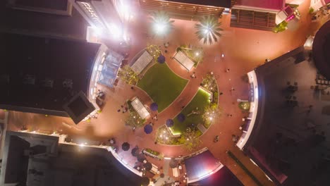 top-down-view-of-a-vibrant-outdoor-courtyard-in-front-of-a-movie-theatre-with-a-drone-time-lapse-people-socialize-dine-shop-and-make-memories-as-they-gather-before-catching-a-film