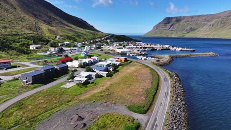 Aerial-View-of-Sudureyri,-Iceland,-Fishing-Village,-Fjord,-Buildings-and-Port-on-Sunny-Day