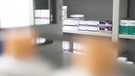 Stocks-Of-Medicines-In-Boxes-At-The-Shelf-Of-A-Pharmacy---selective-focus-trucking-shot