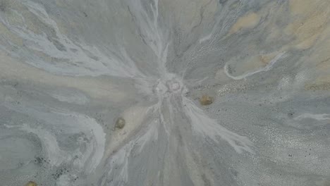 Wonderful-drone-shot,-over-the-dry,-desert-lands-of-a-mud-volcano-with-fissures-in-the-ground