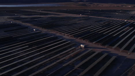 Vista-Aérea-De-La-Planta-De-Energía-Solar-Al-Atardecer,-Paneles-Solares-En-El-Paisaje-Desértico