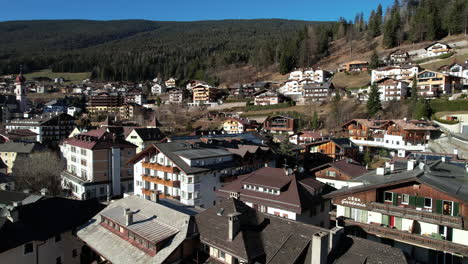 Aerial-View-of-Val-Gardena,-Italy,-Apartment-Buildings-and-Homes-on-Sunny-Spring-Day,-Drone-Shot
