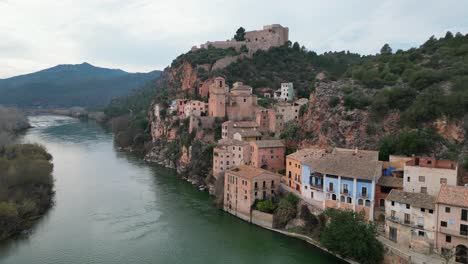 Miravet,-Eine-Malerische-Stadt-In-Tarragona,-Spanien,-An-Einem-Ruhigen-Fluss,-Luftaufnahme